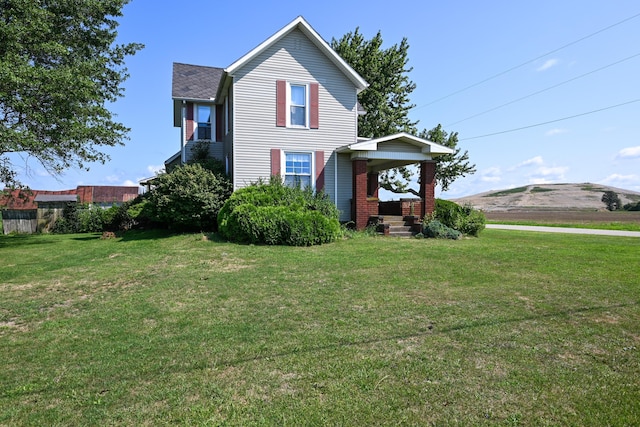 view of side of home featuring a lawn and a mountain view