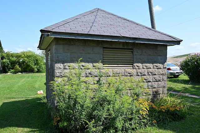 view of side of home with a lawn and an outdoor structure