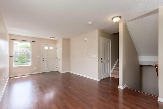 entrance foyer featuring dark hardwood / wood-style floors and vaulted ceiling