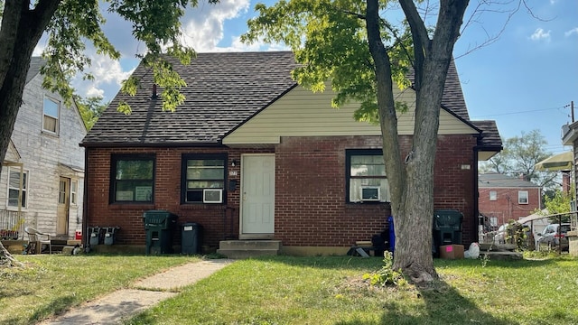 view of front of house with cooling unit and a front lawn