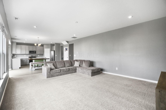 unfurnished living room featuring light colored carpet and a chandelier