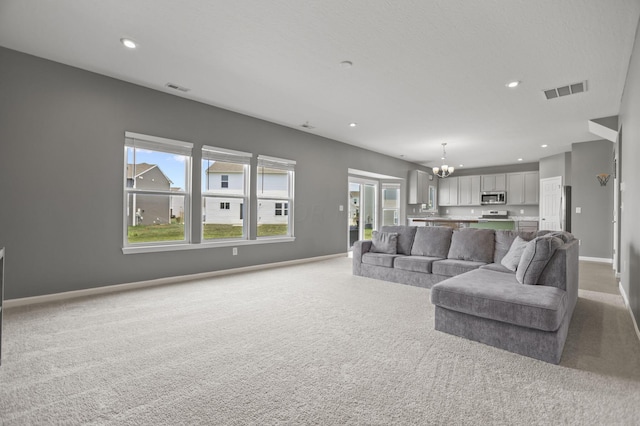 living room with a notable chandelier and light colored carpet