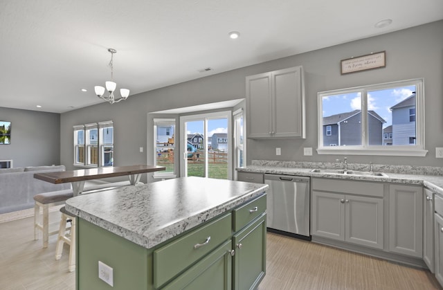 kitchen with an inviting chandelier, stainless steel dishwasher, decorative light fixtures, a kitchen island, and green cabinetry