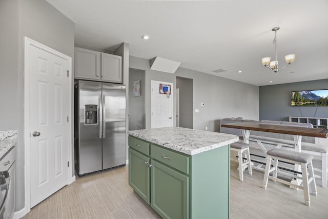 kitchen with stainless steel refrigerator with ice dispenser, decorative light fixtures, an inviting chandelier, a kitchen island, and green cabinets