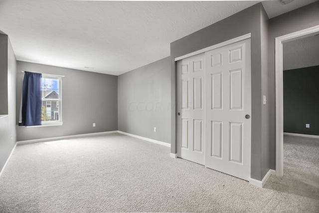 unfurnished bedroom with light colored carpet and a closet