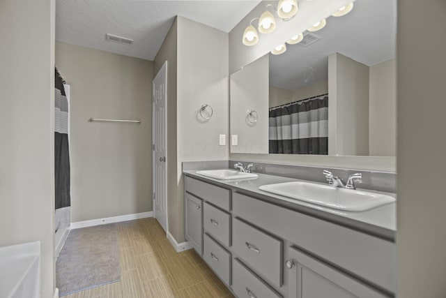 bathroom with a shower with curtain, vanity, and a textured ceiling