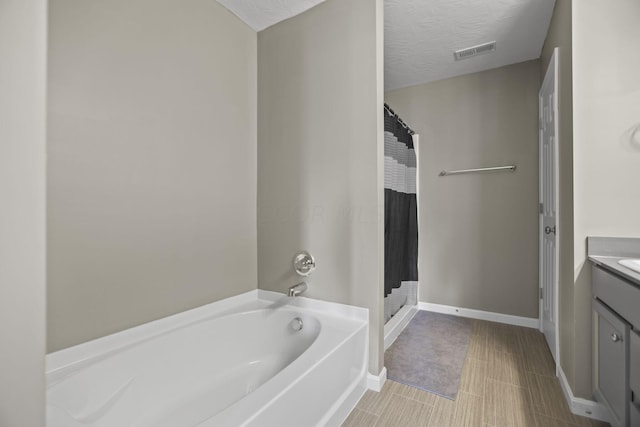 bathroom featuring vanity, shower with separate bathtub, and a textured ceiling