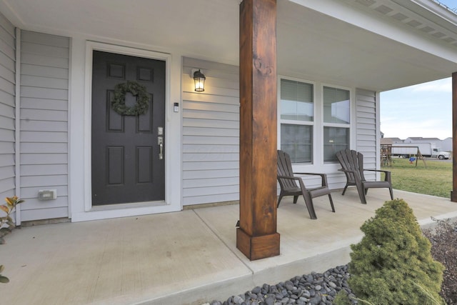 view of exterior entry featuring covered porch