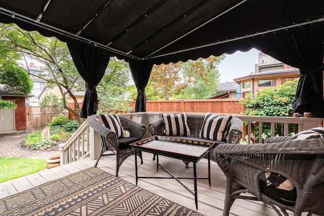 wooden terrace with an outdoor hangout area and a patio