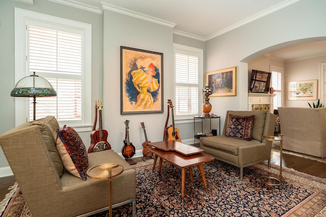 living room featuring ornamental molding, a tiled fireplace, and hardwood / wood-style floors