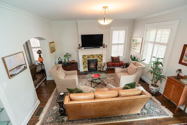 living room featuring crown molding, a brick fireplace, and dark hardwood / wood-style flooring