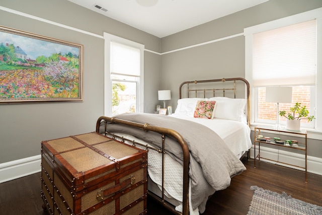 bedroom with dark hardwood / wood-style floors