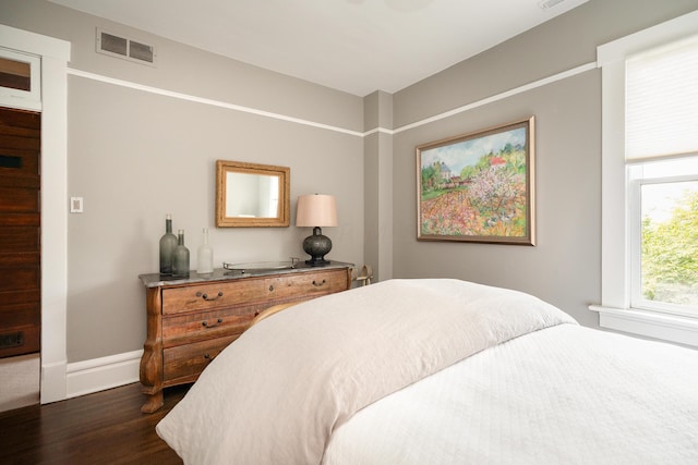 bedroom with dark hardwood / wood-style flooring