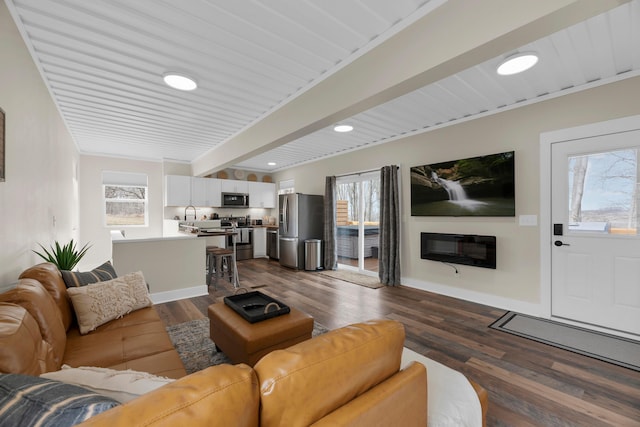 living room featuring plenty of natural light and dark hardwood / wood-style floors