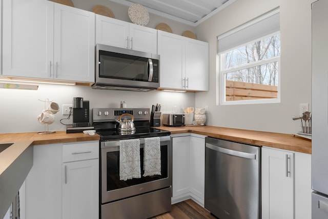 kitchen featuring dark hardwood / wood-style flooring, white cabinets, wooden counters, and appliances with stainless steel finishes