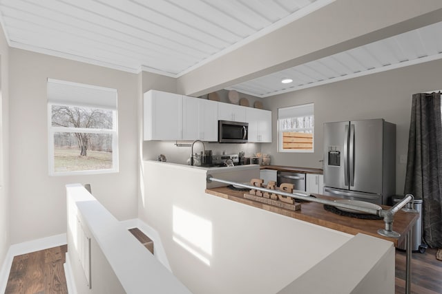 kitchen with wood ceiling, appliances with stainless steel finishes, ornamental molding, dark hardwood / wood-style floors, and white cabinets