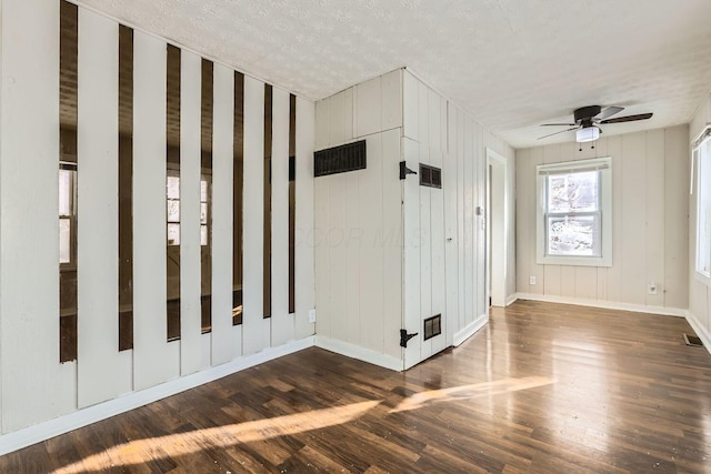 foyer entrance with dark hardwood / wood-style flooring, ceiling fan, and a textured ceiling