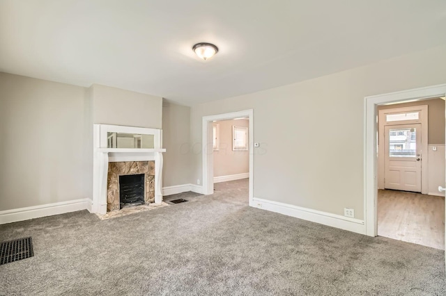 53 N Warren Ave, Columbus, OH 43204 - unfurnished living room featuring carpet flooring, a tiled fireplace, and baseboards