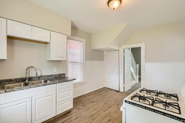 53 N Warren Ave, Columbus, OH 43204 - kitchen featuring a sink, light wood-style floors, white range with gas cooktop, white cabinets, and wainscoting