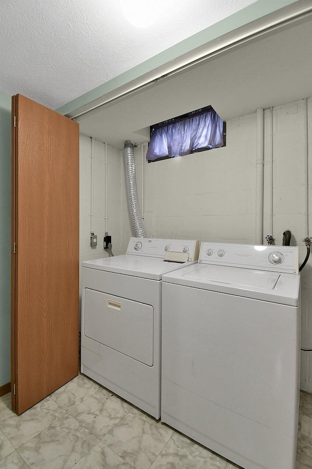 washroom with washer and dryer and a textured ceiling