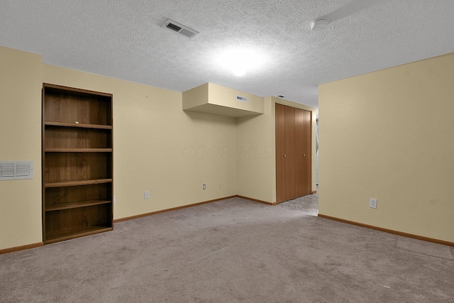 carpeted empty room featuring a textured ceiling