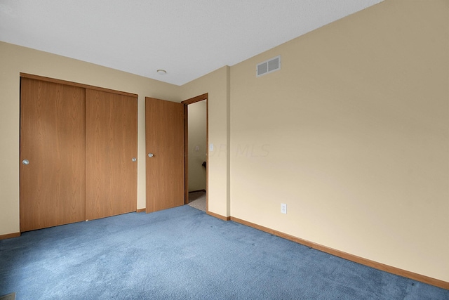 unfurnished bedroom featuring light carpet and a closet