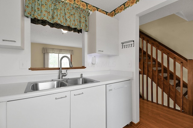 kitchen with white cabinets, a textured ceiling, dark wood-type flooring, sink, and dishwasher