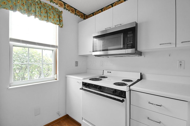 kitchen with white cabinets, electric stove, and hardwood / wood-style floors