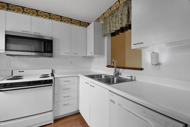 kitchen featuring white cabinetry, sink, light hardwood / wood-style flooring, a textured ceiling, and white appliances