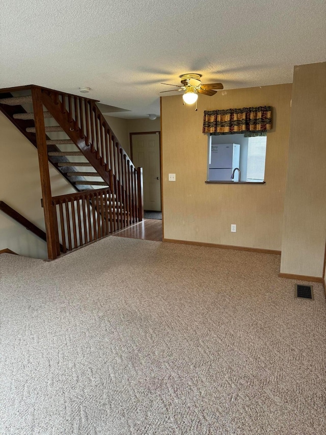 interior space with ceiling fan, sink, and a textured ceiling