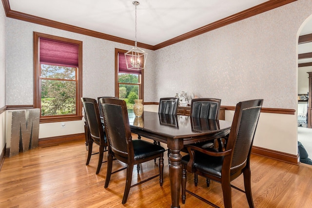 dining area featuring a notable chandelier, light hardwood / wood-style floors, and ornamental molding