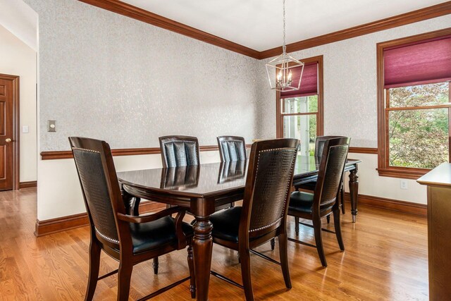 dining area featuring an inviting chandelier, light hardwood / wood-style flooring, plenty of natural light, and ornamental molding