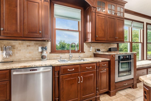 kitchen with appliances with stainless steel finishes, plenty of natural light, crown molding, and sink