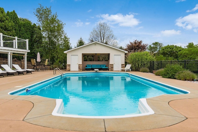 view of swimming pool with an outbuilding and a patio area