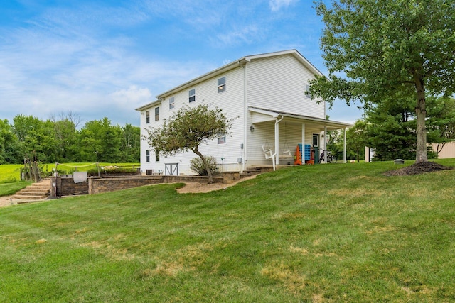 rear view of property featuring a lawn