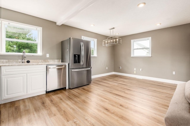 kitchen featuring a healthy amount of sunlight, light hardwood / wood-style flooring, stainless steel appliances, and sink