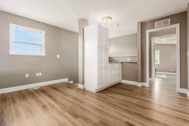 interior space featuring light wood-type flooring and a textured ceiling