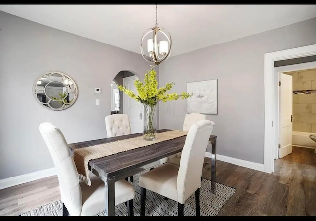 dining room featuring a notable chandelier and dark wood-type flooring