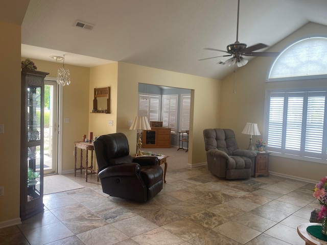 living room featuring ceiling fan with notable chandelier, plenty of natural light, and lofted ceiling