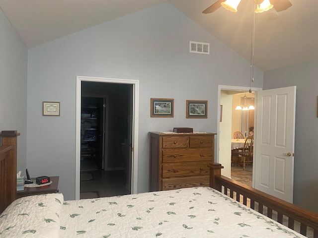 bedroom with ceiling fan with notable chandelier, high vaulted ceiling, and ensuite bath