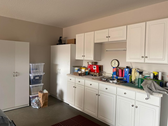 kitchen with white cabinets and a textured ceiling