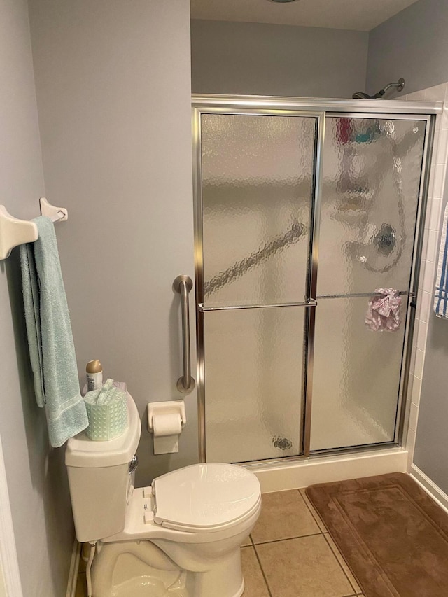 bathroom featuring tile patterned floors, toilet, and walk in shower