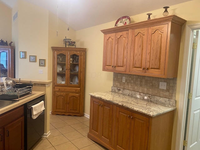 kitchen with backsplash, light stone counters, light tile patterned floors, and black dishwasher