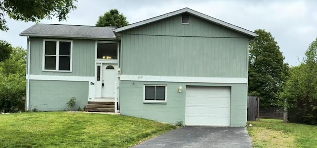5972 Hampstead Ln, Columbus, OH 43229 - bi-level home with a front yard, asphalt driveway, an attached garage, and roof with shingles