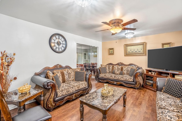 living room featuring light hardwood / wood-style floors and ceiling fan with notable chandelier