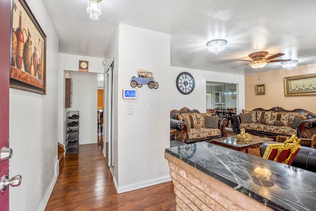 living room featuring ceiling fan and dark wood-type flooring