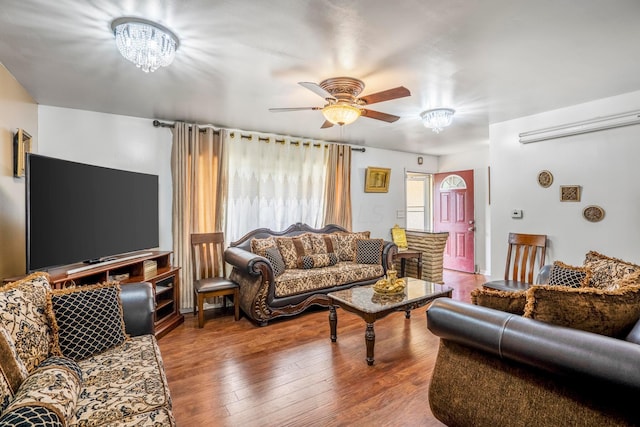 living room featuring wood-type flooring and ceiling fan with notable chandelier