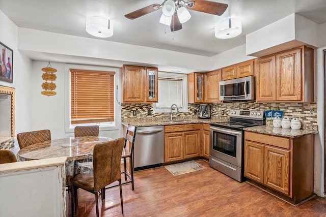 kitchen featuring backsplash, hardwood / wood-style flooring, sink, and appliances with stainless steel finishes