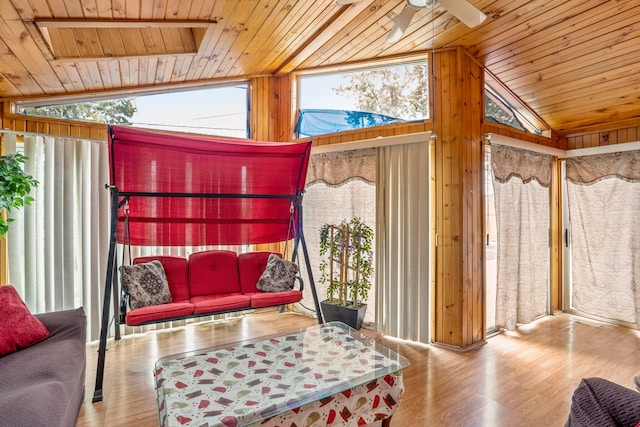 living room with wood walls, light hardwood / wood-style flooring, wooden ceiling, and vaulted ceiling