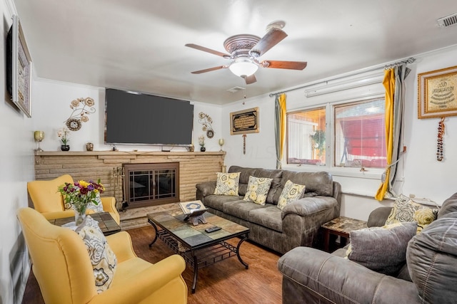 living room with crown molding, a fireplace, ceiling fan, and hardwood / wood-style flooring